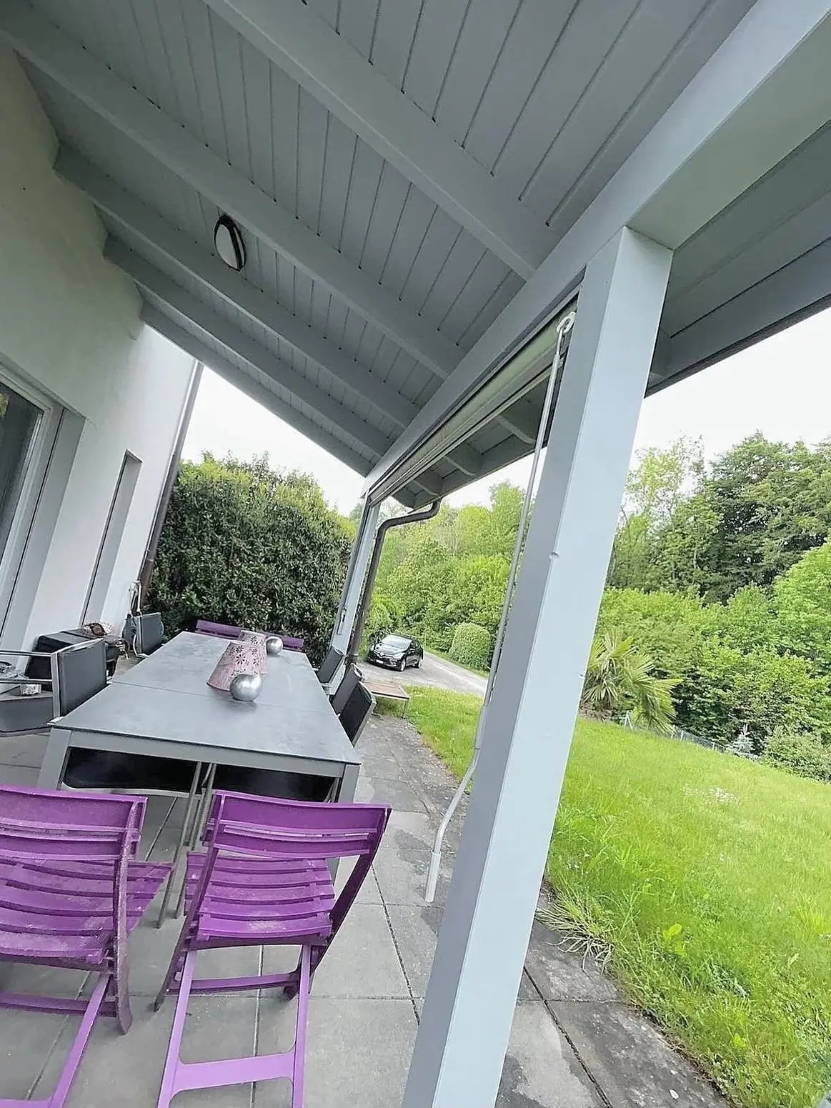 Terrasse couverte ouverte sur le jardin, poutres en teinte noyer